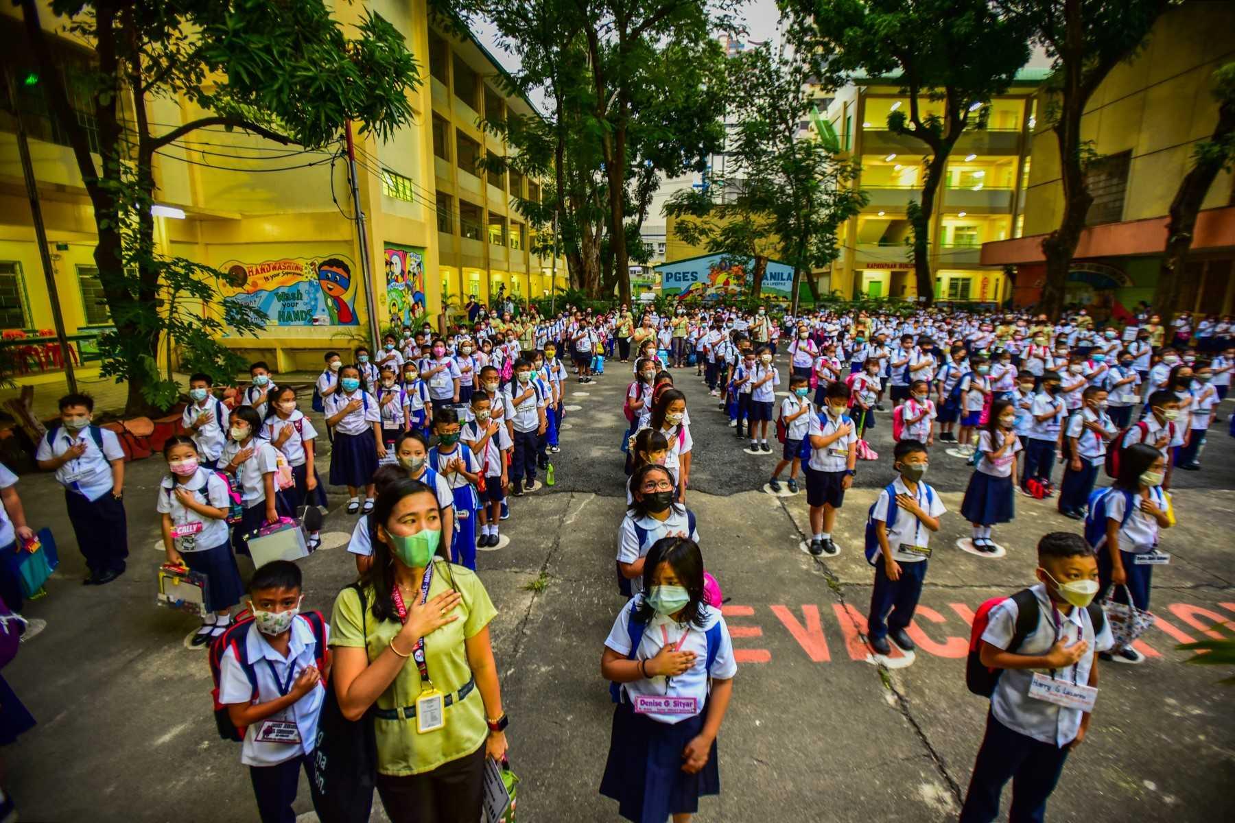 Students attend a flag-raising ceremony before singing the national anthem on the first day of in-person classes after years-long Covid-19 lockdowns at Pedro Guevara Elementary School in Manila on Aug 22. Photo: AFP 