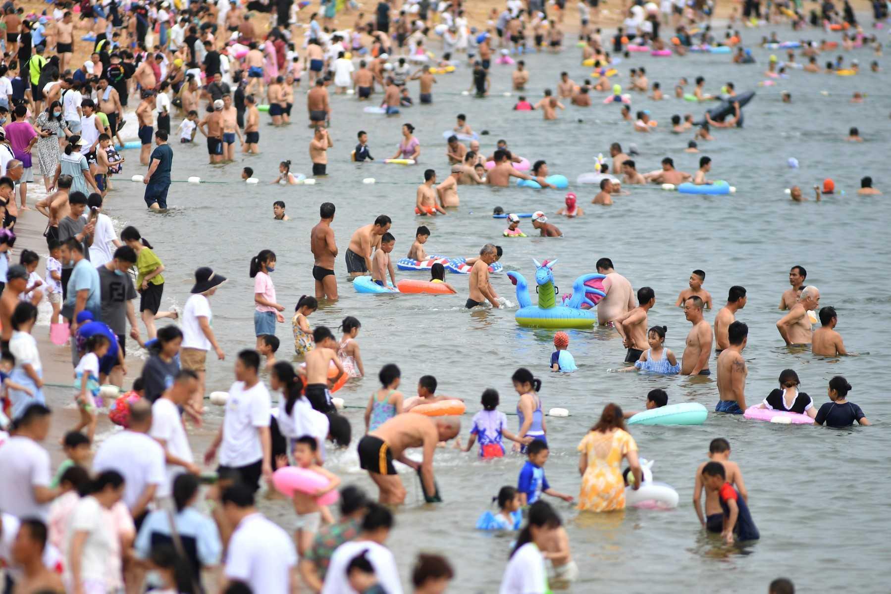 This photo taken on July 10 shows people cooling off on a beach in Qingdao, in China's eastern Shandong province. Photo: AFP