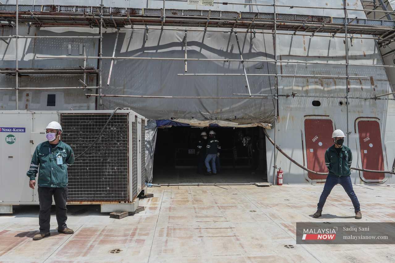 Boustead Naval Shipyard officers stand on one of the six littoral combat ships commissioned for the navy at Lumut in Perak.