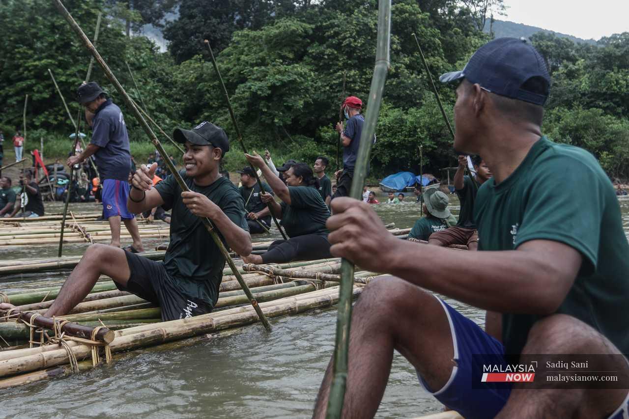Meanwhile at the river, Orang Asli from the Seletar Laut tribe prepare for a raft  race. 