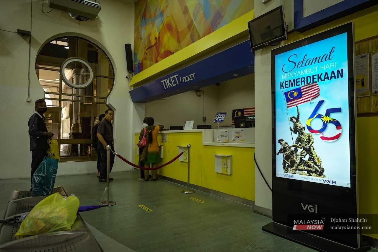 A small digital billboard reminds commuters queuing at the ETS ticket counter of the upcoming Merdeka Day celebration. 