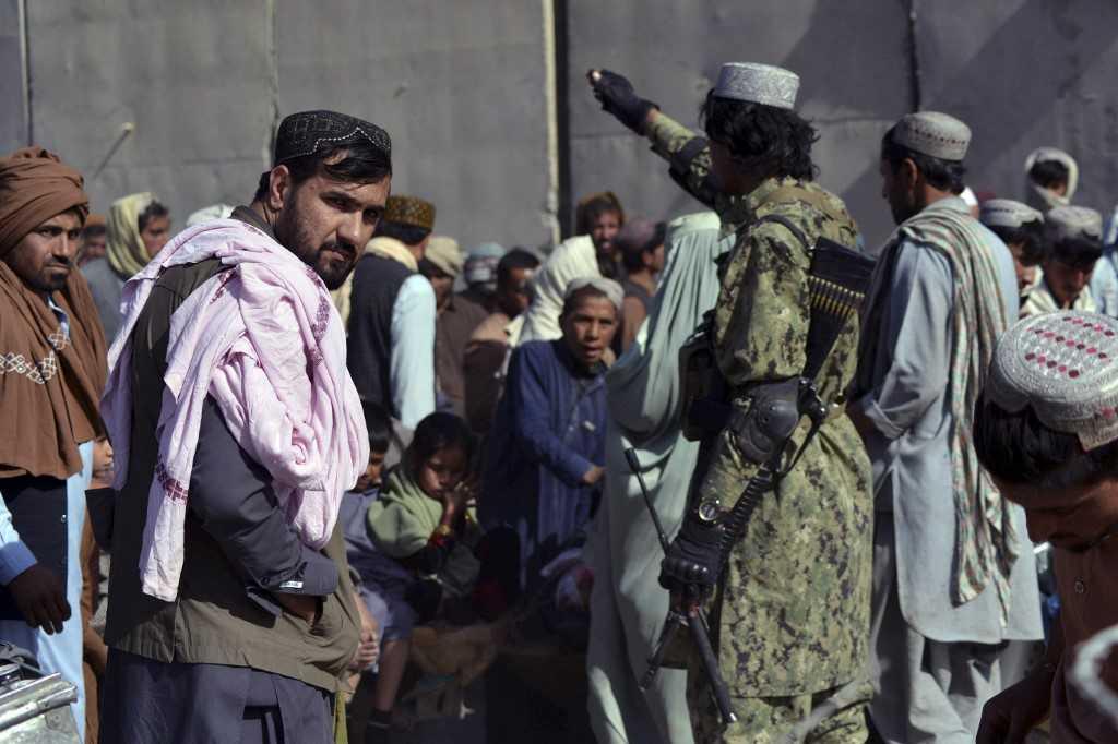 Anggota Taliban (kanan) mengarahkan orang ramai menunggu bagi merentas sempadan menuju Pakistan di Spin Boldak pada 3 November 2021. Gambar: AFP
