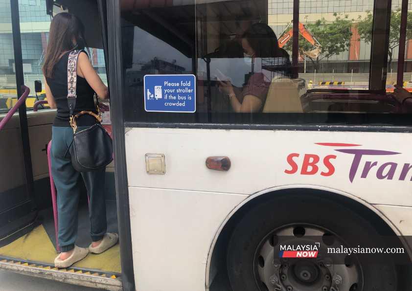 A passenger boards a SBS Transit bus in Singapore. A number of former bus drivers claim to have been treated unfairly by the public transport company. 
