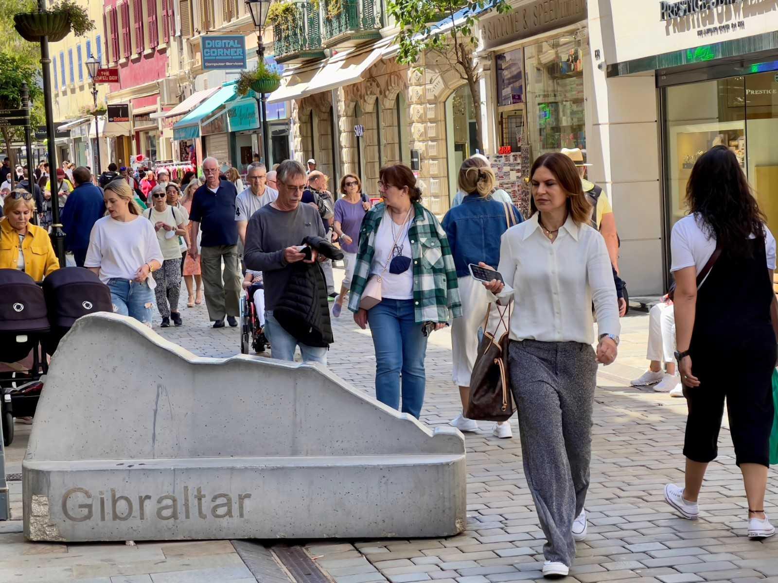 A stone marker in the shape of the Rock of Gibraltar is seen as tourists walk on main street in Gibraltar, on May 5. Photo: AFP 