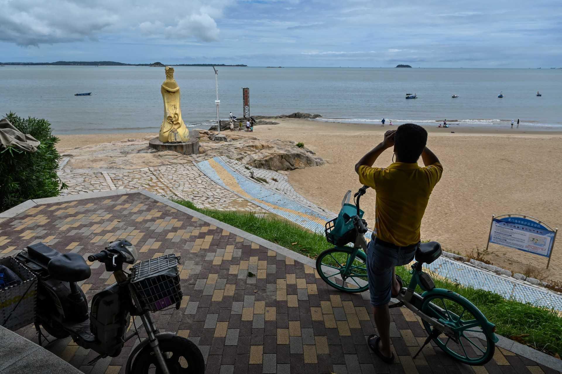 A man looks through a pair of binoculars in Xiamen, across Taiwan's Kinmen Islands on Aug 3. Photo: AFP