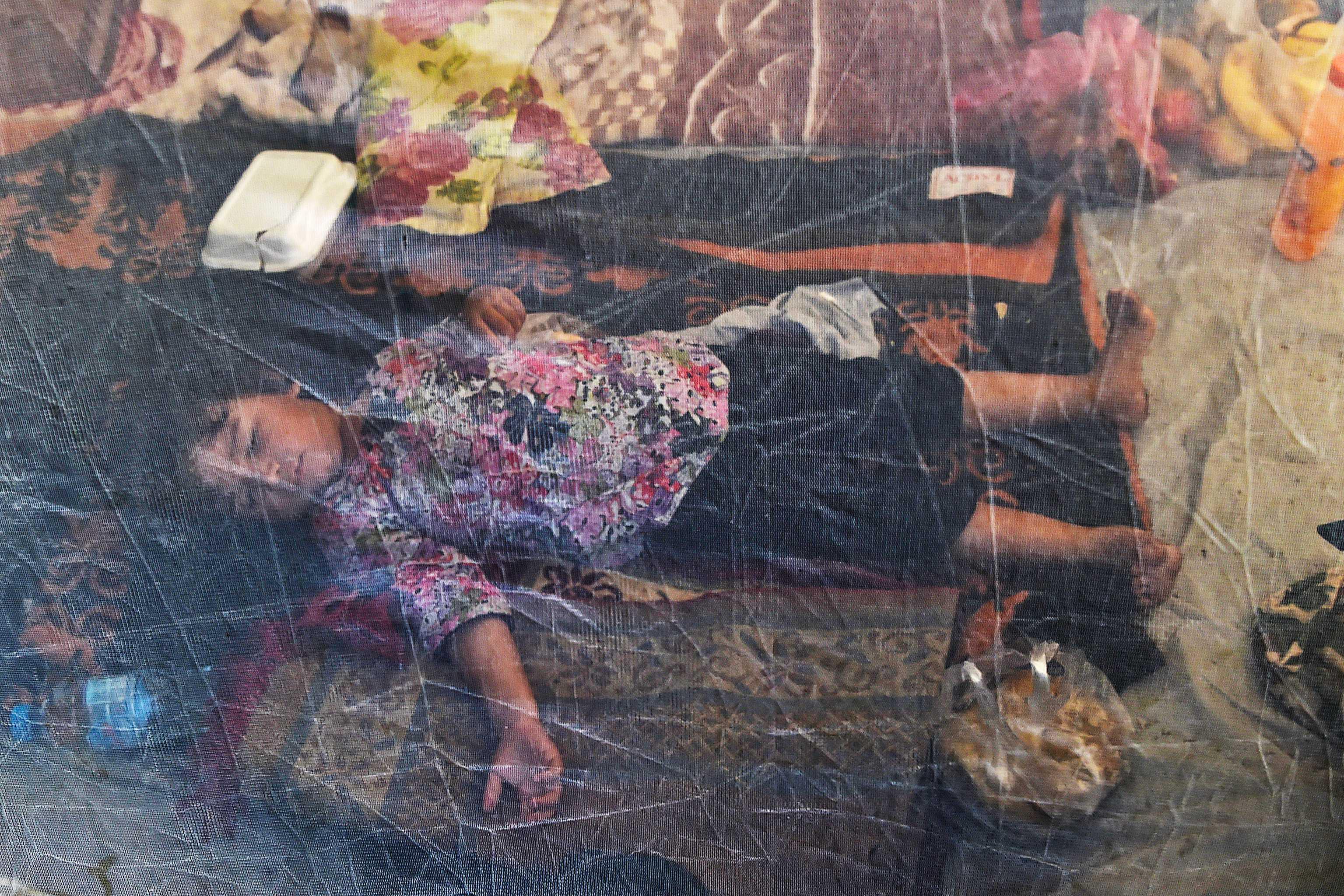 A displaced child sleeps under a mosquito net in a tent at a makeshift camp after fleeing from flood hit home following heavy monsoon rains in Charsadda district of Khyber Pakhtunkhwa on Aug 29. Photo: AFP