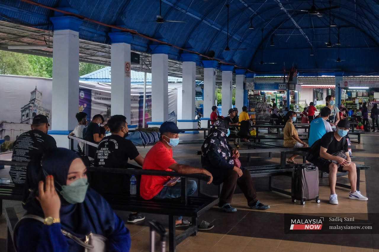 People wait for a bus at the Bentayan bus station in Muar, Johor. 
