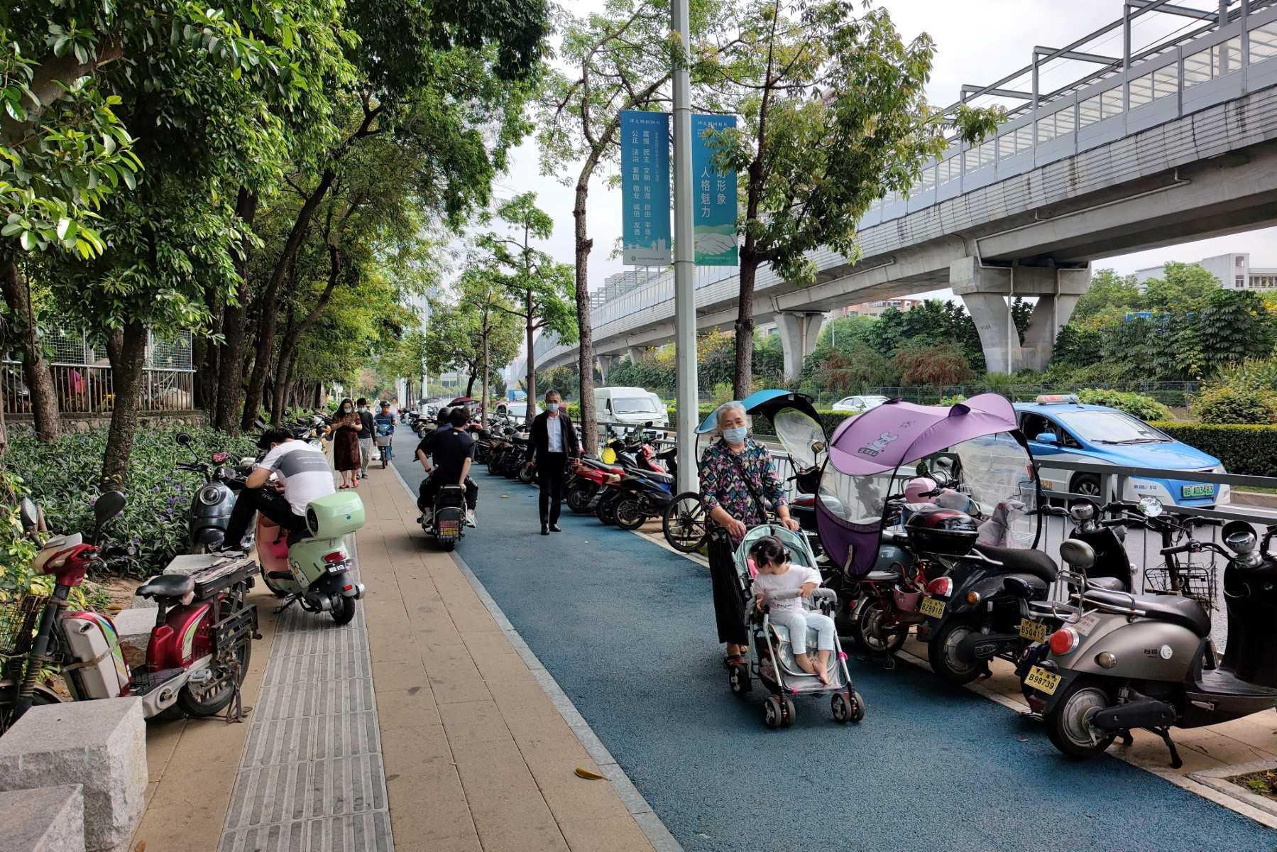 This photo taken on March 21, shows residents walking along a street after the city was reopened following a lockdown against a Covid-19 coronavirus outbreak in Shenzhen in China's southern Guangdong province. Photo: AFP