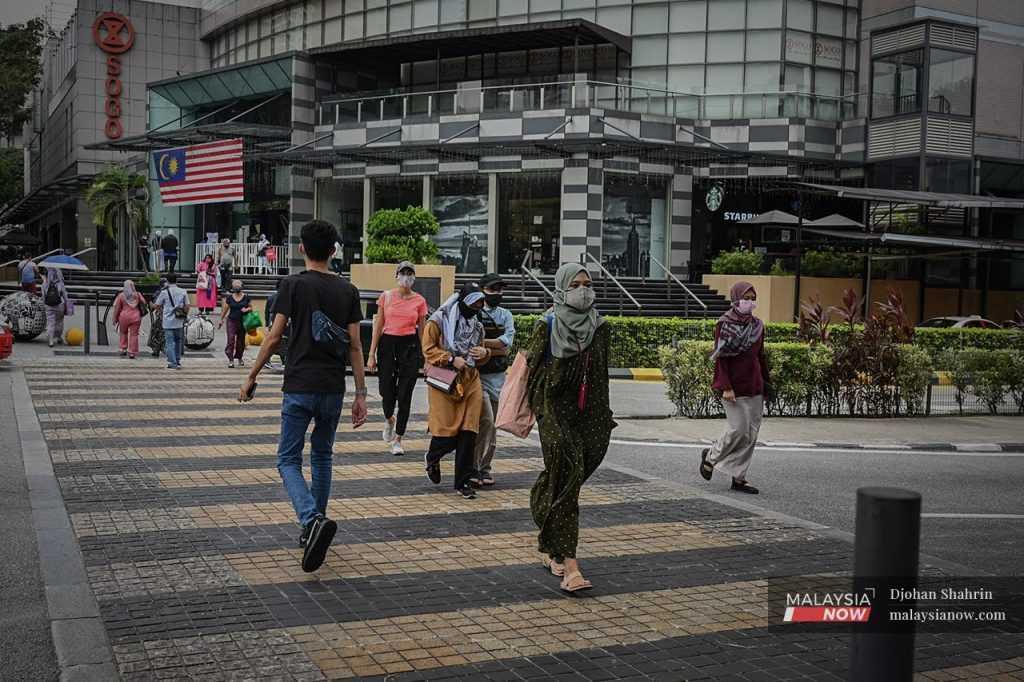 Pedestrians cross a road at Jalan Tuanku Abdul Rahman in Kuala Lumpur.