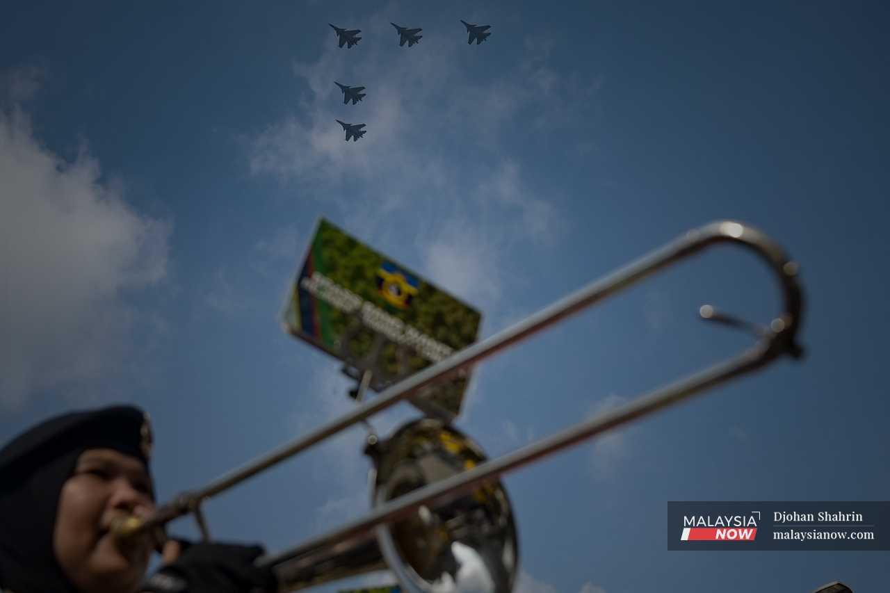 Fighter jets fly in formation overhead. 
