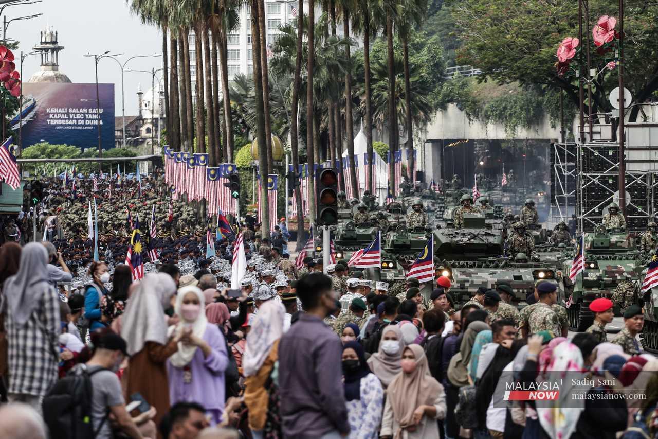 Orang ramai berkumpul menyaksikan kawad perbarisan Angkatan Tentera Malaysia ketika sesi raptai perarakan Hari Kebangsaan  di Dataran Merdeka, Kuala Lumpur.
