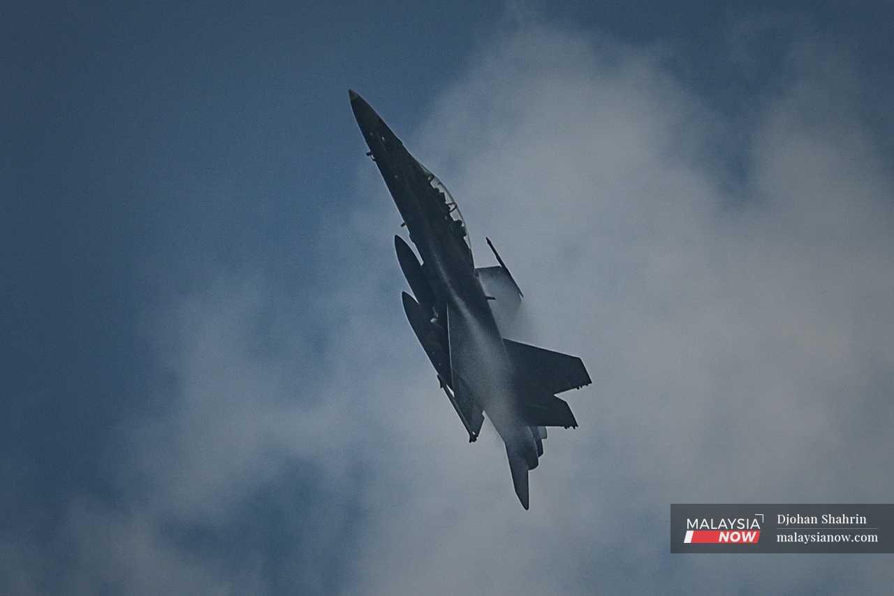 A F/A-18D Hornet jet soars through the air over the parade at Dataran Merdeka. 