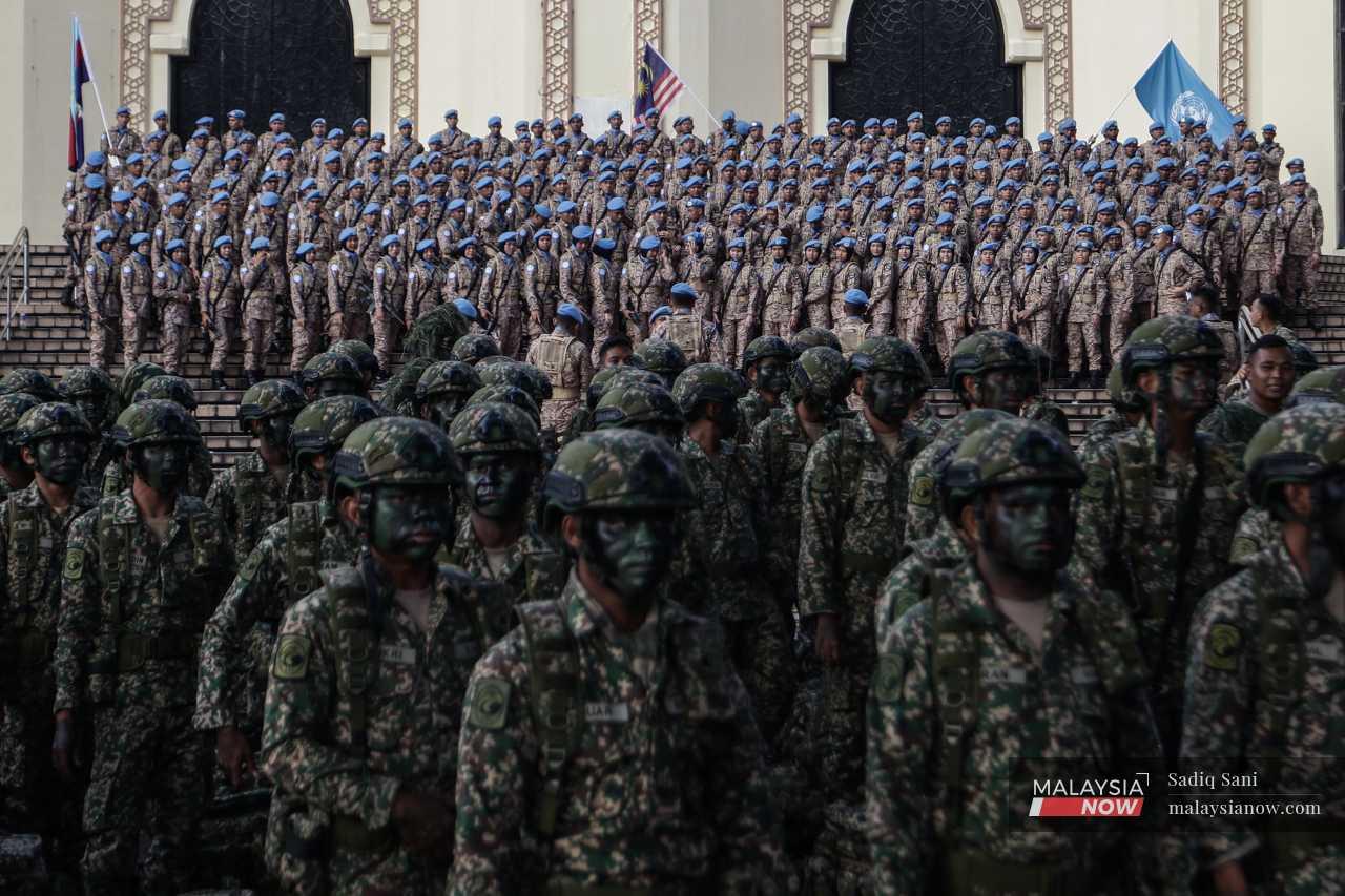 Contingents of soldiers gather before participating in the final rehearsal before Merdeka Day. 