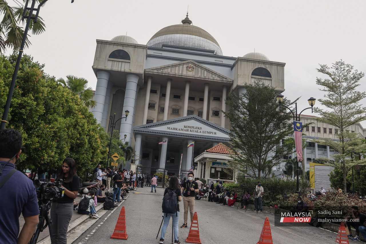 Reporters wait outside the Kuala Lumpur court complex where the High Court is due to give its verdict in Rosmah Mansor's corruption trial.