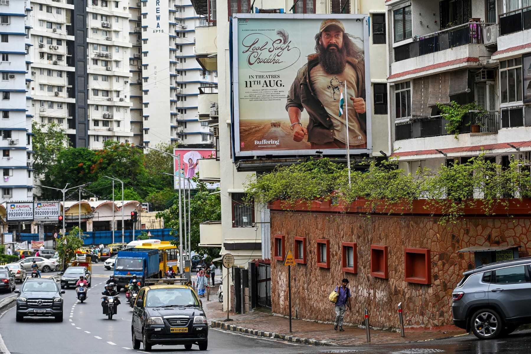 Vehicles drive past a poster of Bollywood film 'Laal Singh Chaddha' put up near a residential building in Mumbai on Aug 8. Photo: AFP
