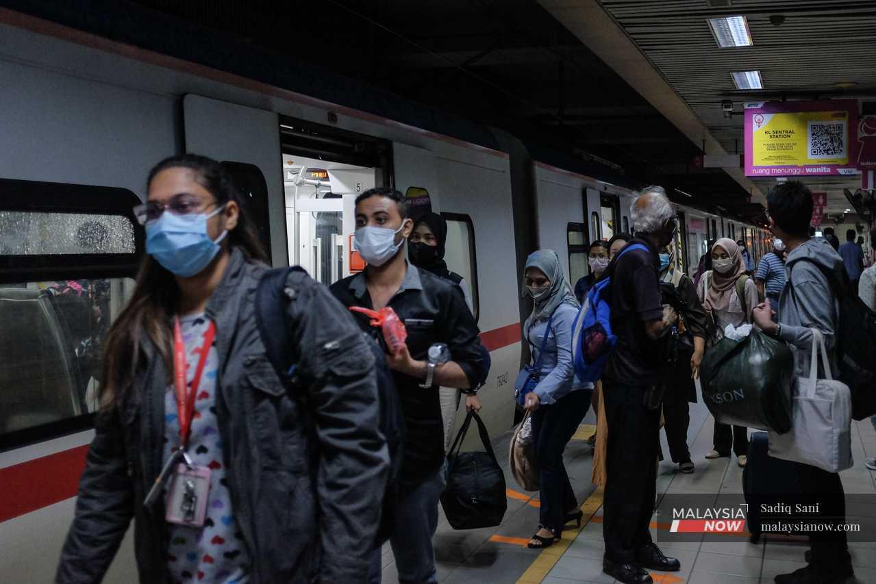Pekerja pejabat turun dari tren untuk pulang ke rumah selepas seharian bekerja di Kuala Lumpur.