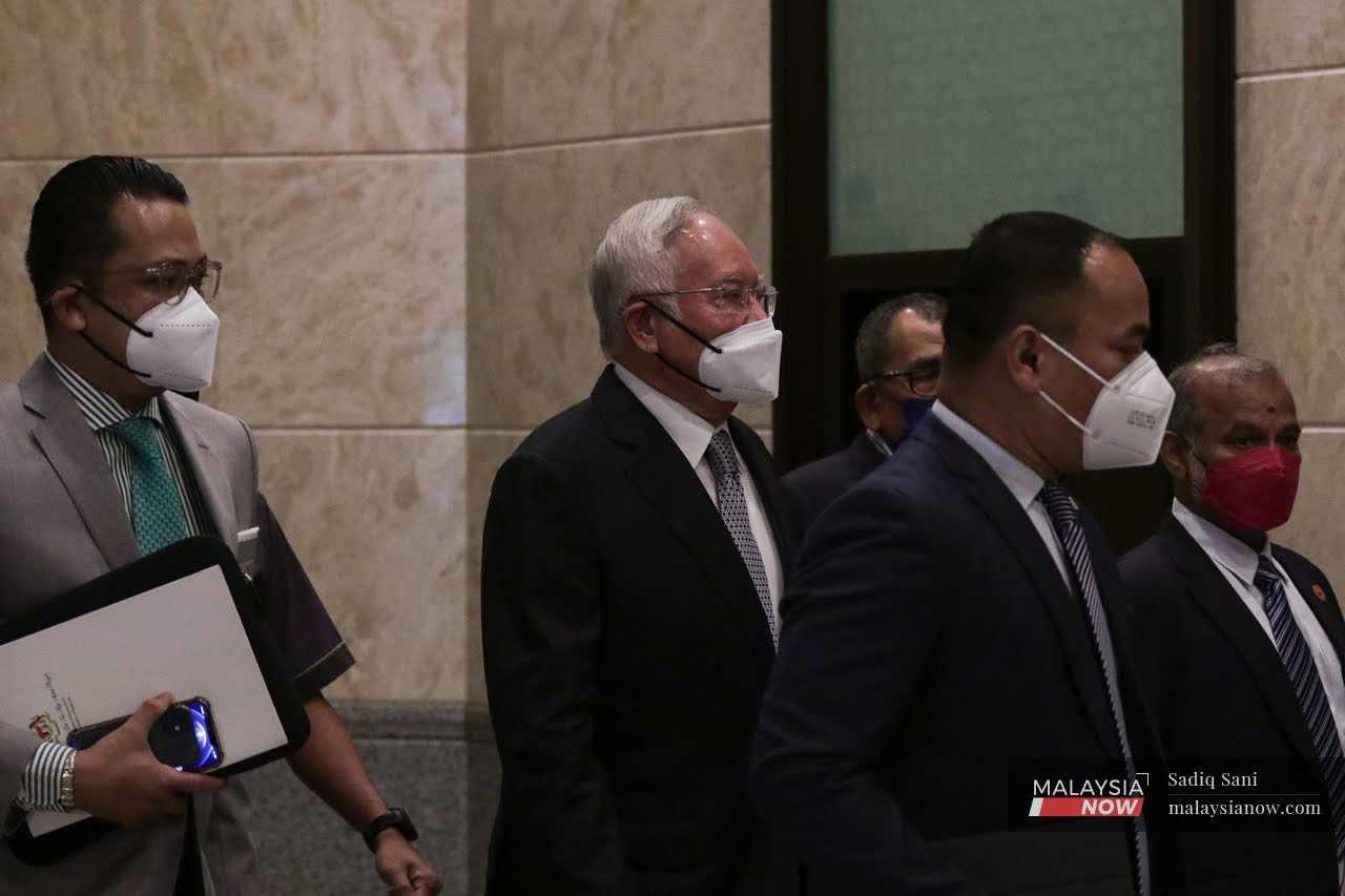 Bekas perdana menteri Najib Razak diiringi masuk ke kamar mahkamah di Kompleks Mahkamah Kuala Lumpur pada 23 Ogos.