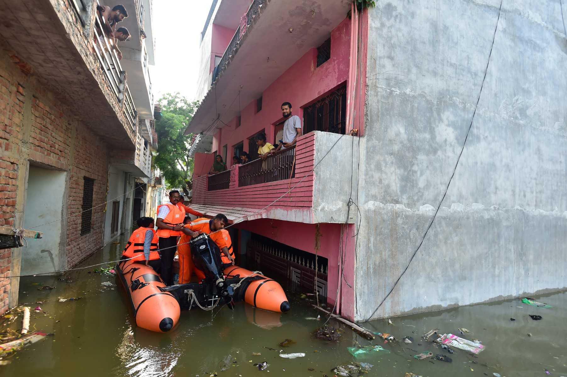 India's National Disaster Response Force personnel distribute food and relief materials to people in flooded areas following heavy monsoon rains that caused the overflowing of the Ganges and Yamuna rivers in Allahabad on Aug 27. Photo: AFP 