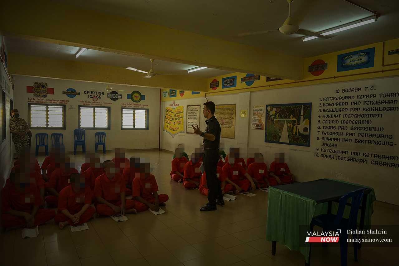 A prison officer gives a briefing to a group of drug offenders.