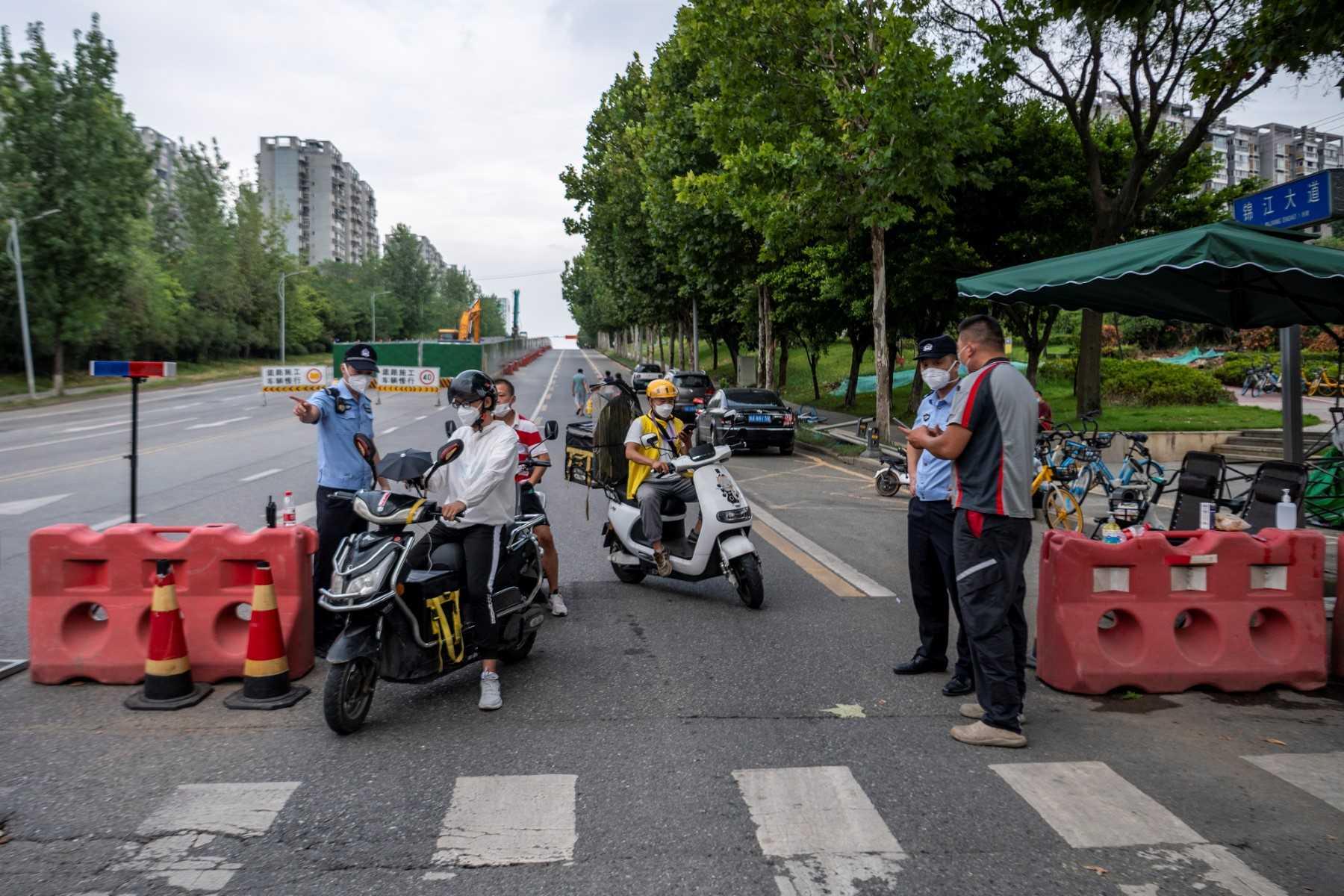 This photo taken on Sept 1, shows police officers checking information on a road amid restrictions due to an outbreak of the Covid-19 coronavirus in Chengdu, in China's southwestern Sichuan province. Photo: AFP
