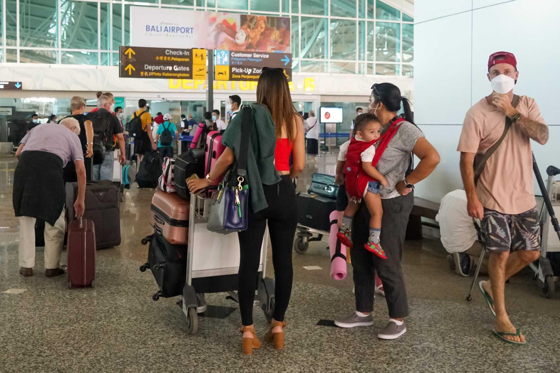 Pelancong beratur di lapangan terbang Bali. Pulau peranginan terkenal Indonesia itu menerima hampir 9,000 pelancong setiap hari. Gambar: AFP