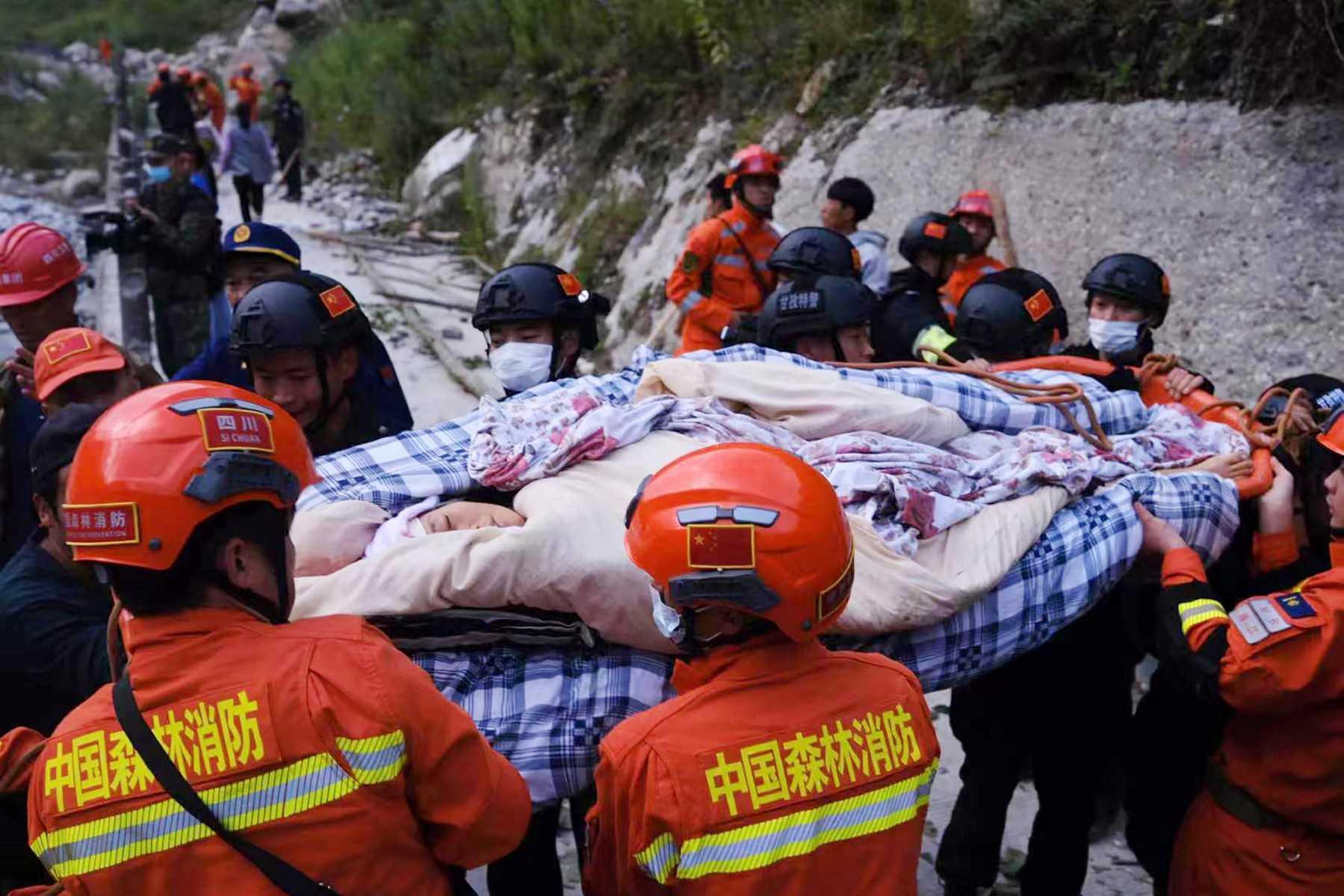 Anggota penyelamat menurunkan seorang mangsa gempa bumi di Sichuan, China. Gambar: AFP