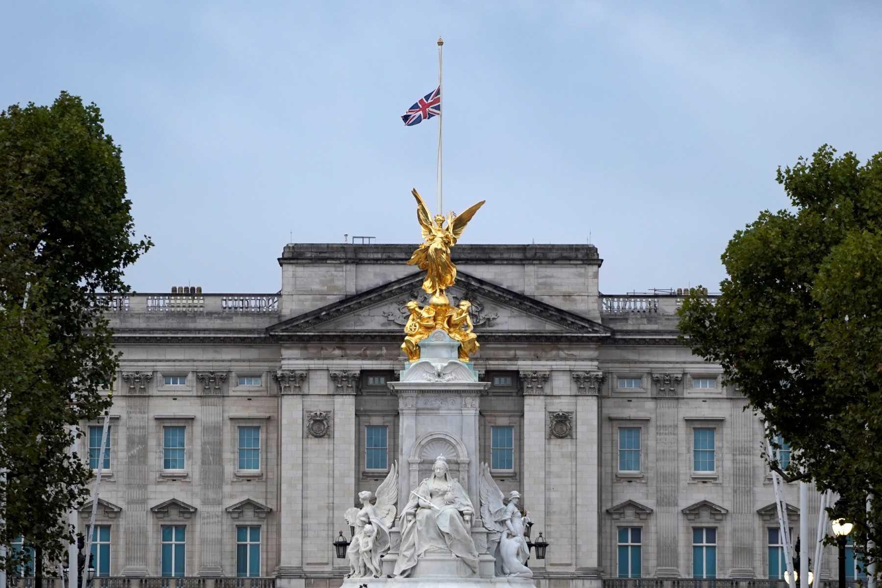 The Union flag flies at half-mast atop Buckingham Palace, beyond the Queen Victoria Memorial statue, in London on Sept 9, a day after Queen Elizabeth II died at the age of 96. Photo: AFP 