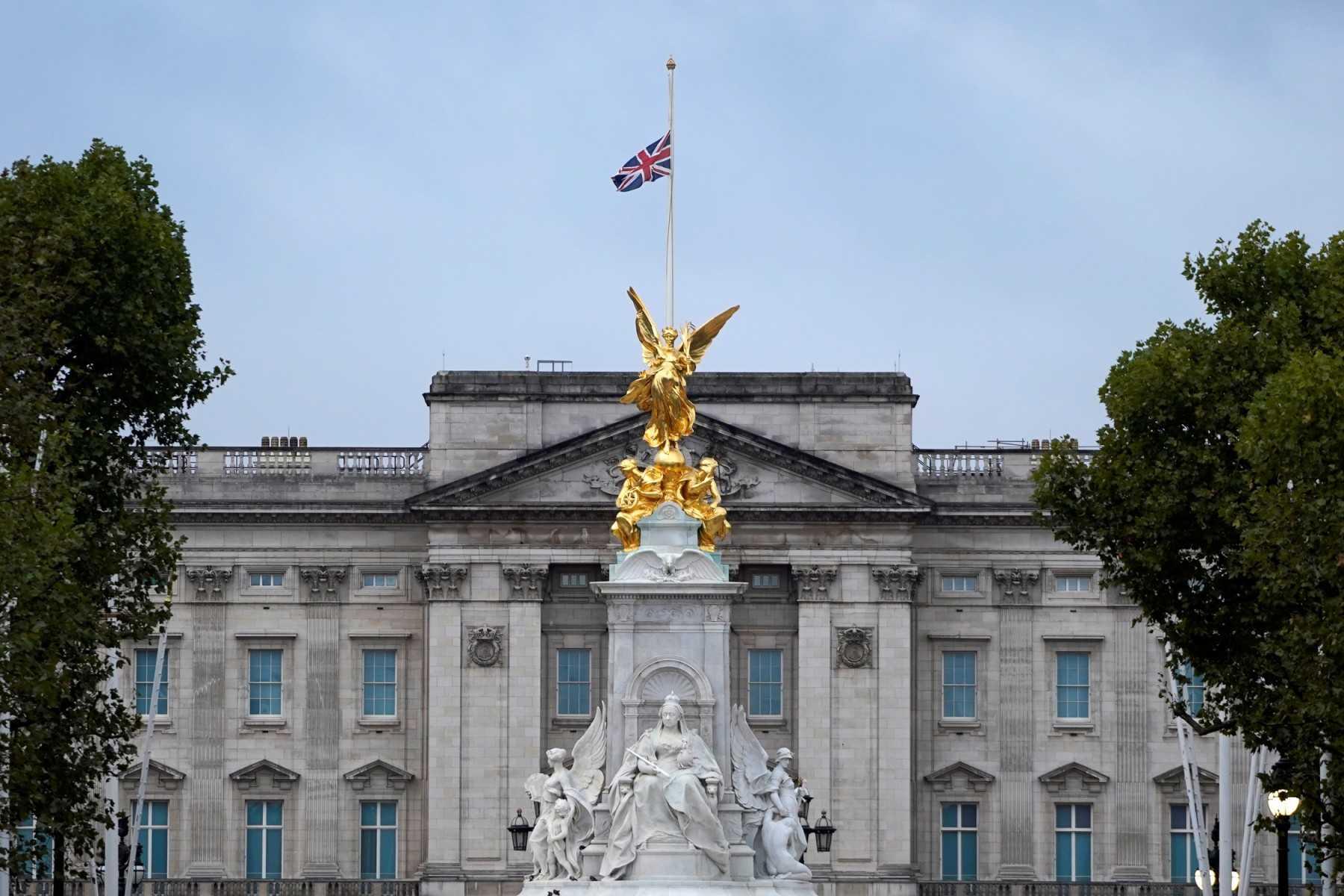 The Union flag flies at half-mast atop Buckingham Palace, beyond the Queen Victoria Memorial statue, in London on Sept 9, a day after Queen Elizabeth II died at the age of 96. Photo: AFP