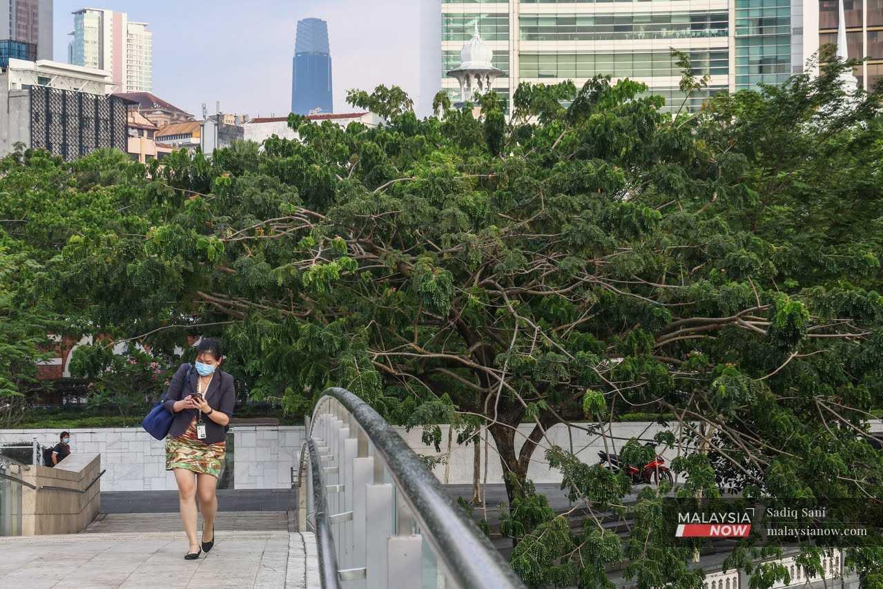 An office worker crosses a pedestrian bridge after work in the capital city of Kuala Lumpur.