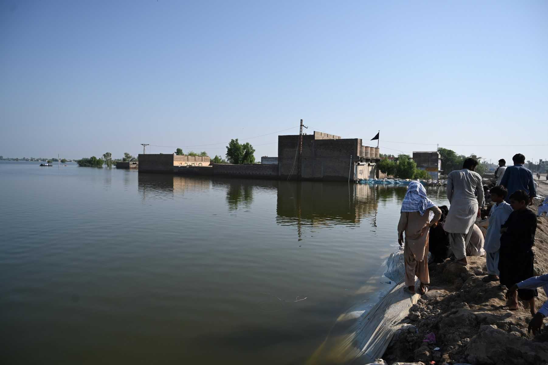 Flood-affected people gather by an embankment in Mehar city after heavy monsoon rains in Dadu district, Sindh province in Pakistan on Sept 9. Photo: AFP