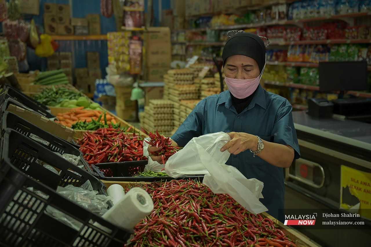 Seorang pelanggan mengambil barangan di Pasar Chow Kit, Kuala Lumpur. Kerajaan sedang membincangkan cadangan moratorium terhadap perniagaan kecil dan sederhana dalam negara.