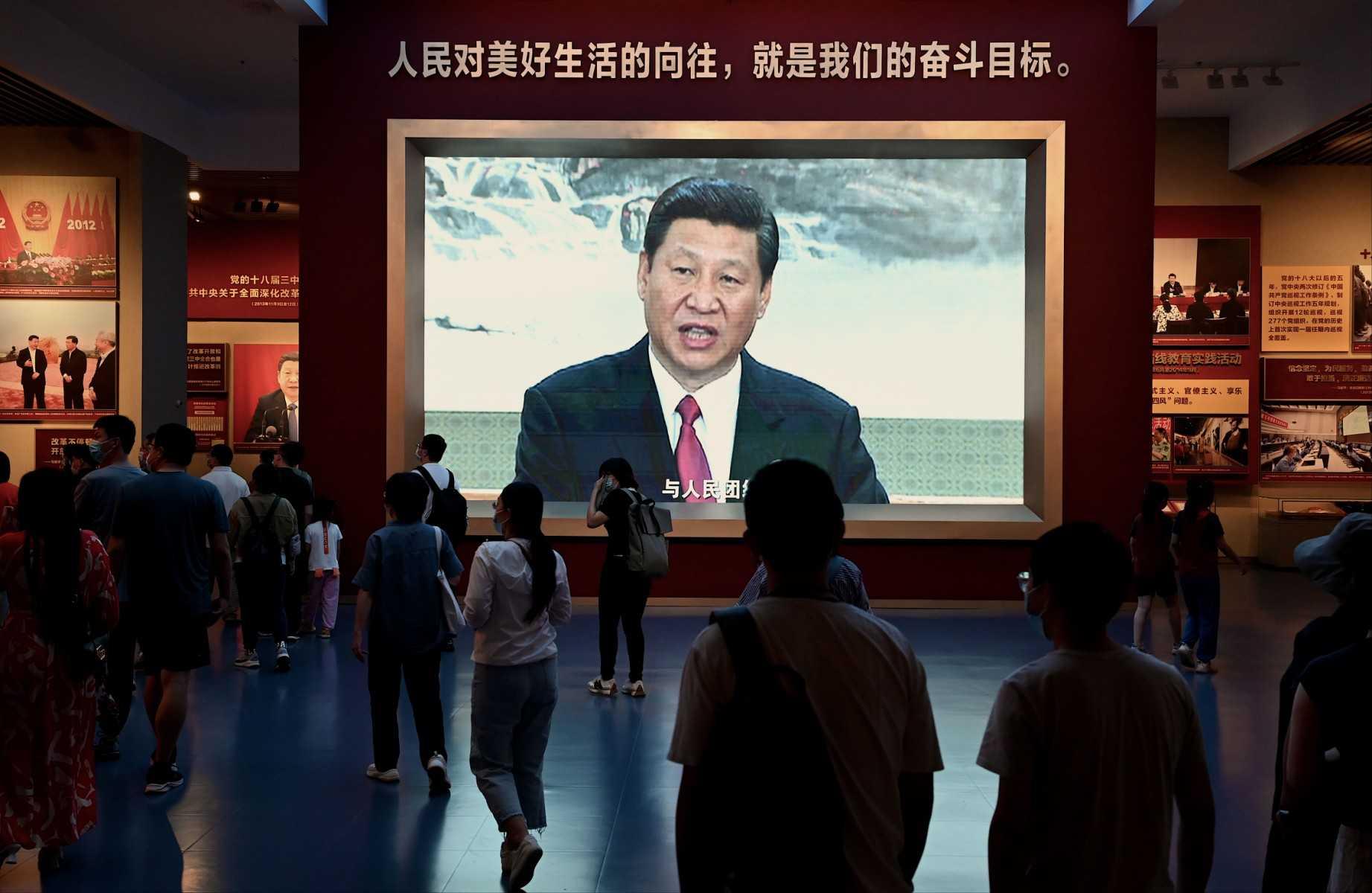 People walk past a screen showing Chinese President Xi Jinping at the Museum of the Communist Party of China in Beijing on Sept 4. Photo: AFP 