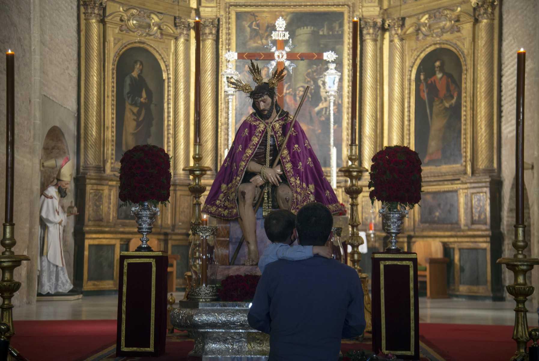 Seorang bapa mendukung anaknya melihat figura Jesus Christ di Geraja San Esteban, Seville pada 30 Mac 2021. Gambar: AFP