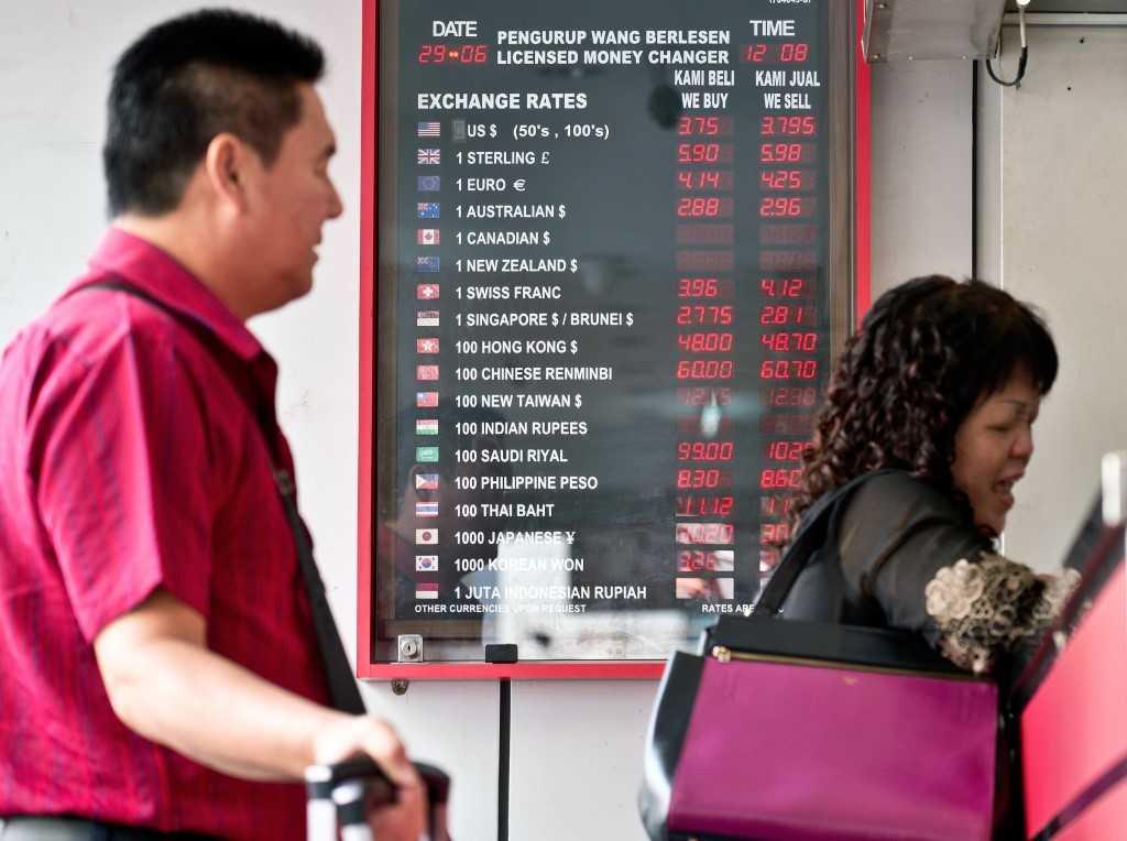 Papan tanda memaparkan nilai ringgit berbanding mata wang lain di premis pengurup wang. Gambar: AFP
