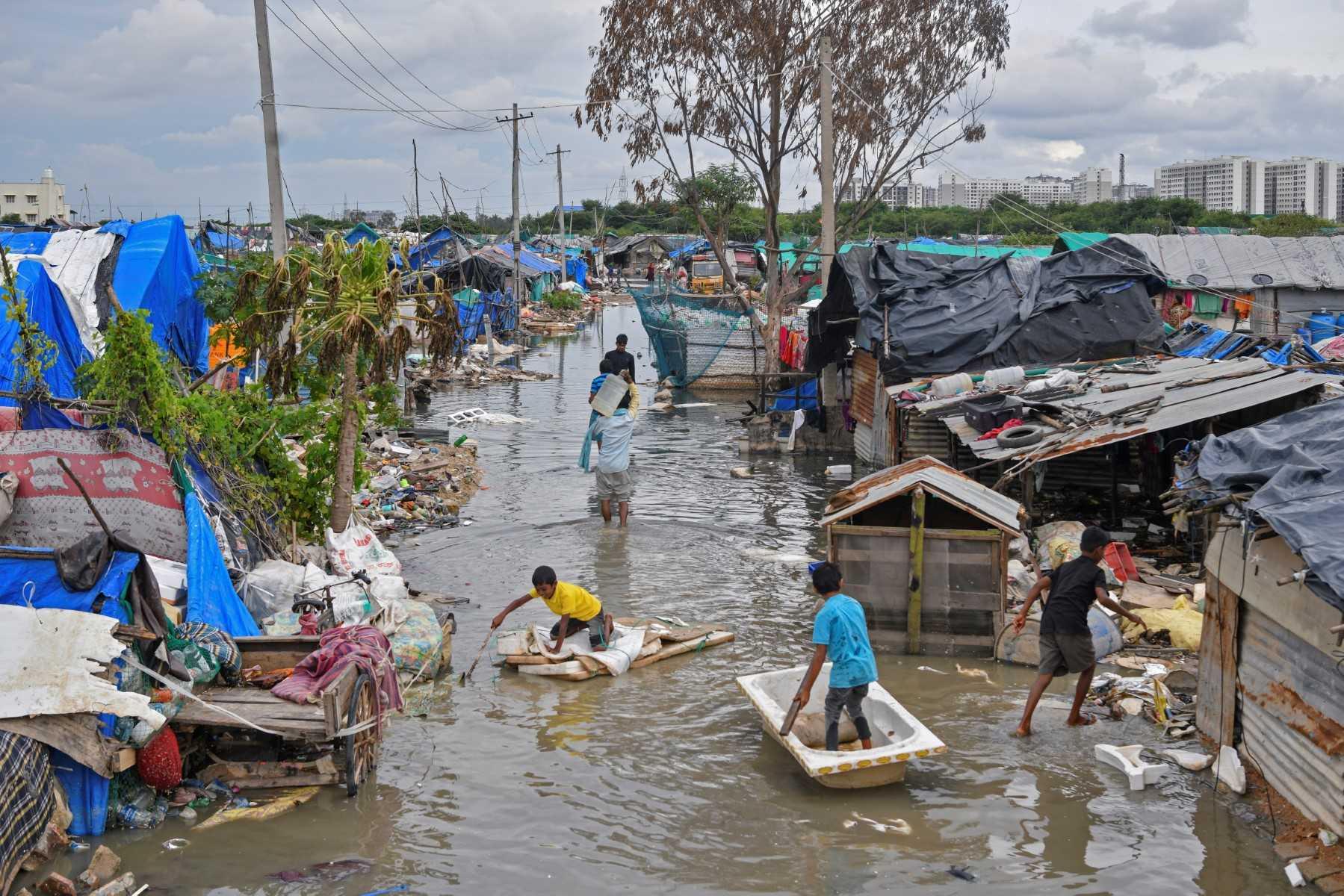 Children of workers living in a slum play around their waterlogged dwelling after heavy rains in Bangalore on Sept 7. Photo: AFP 