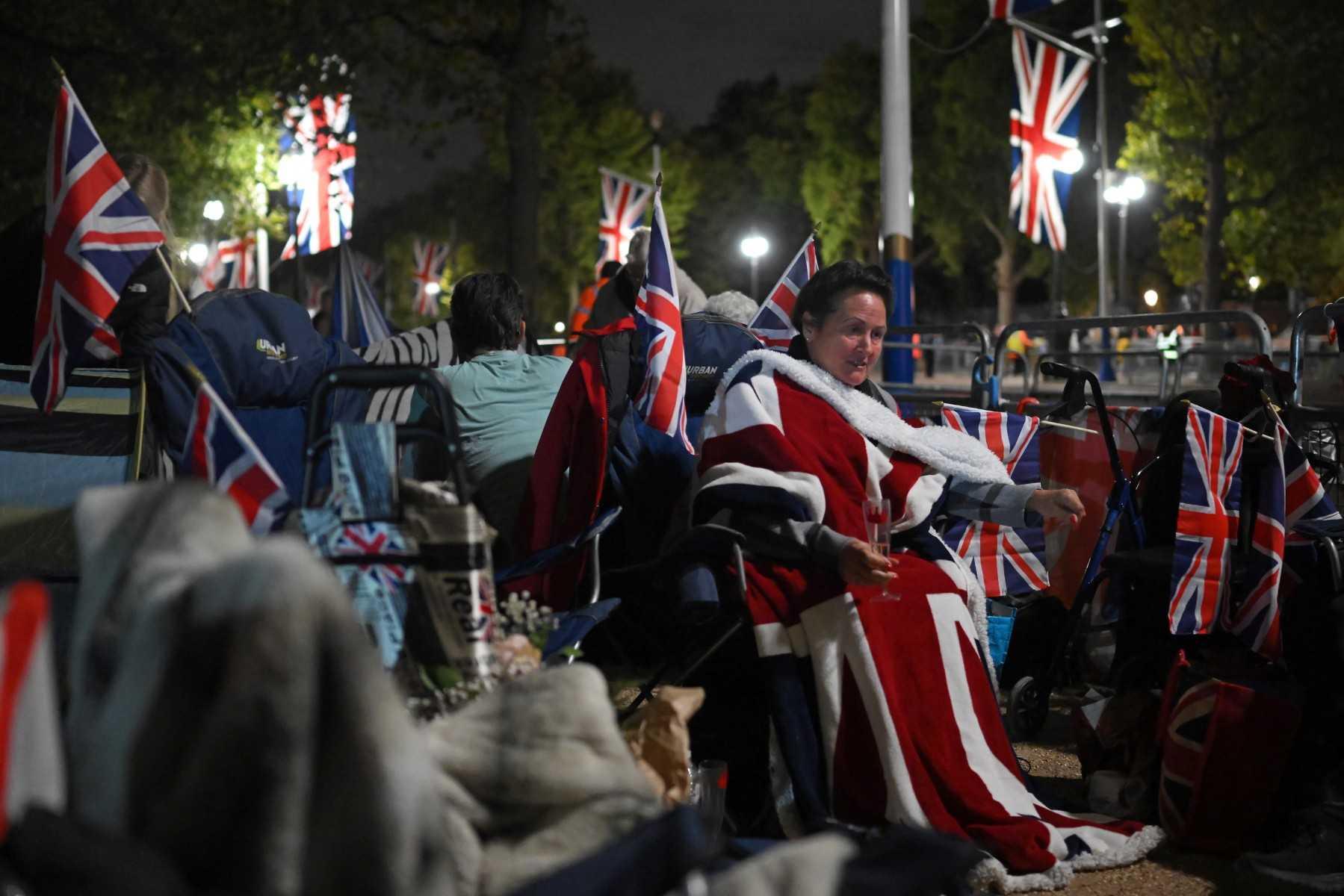 Members of the public camp behind barriers lining the procession route, ahead of the funeral of the late Queen Elizabeth II, in London on Sept 18. Photo: AFP