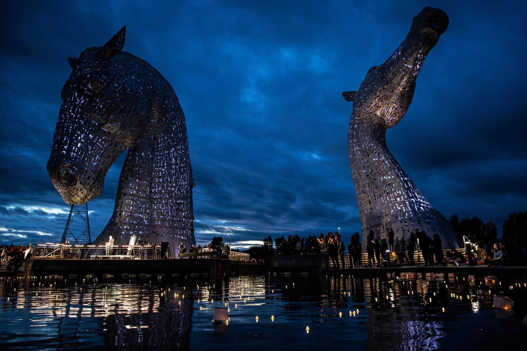 The Kelpies statues are illuminated as members of the public hold a service of reflection to show their respect to the late Queen Elizabeth II, in Falkirk, Scotland on Sept 18, ahead of her State Funeral on Monday. Photo: AFP