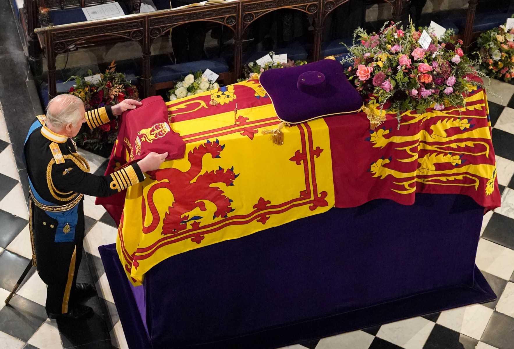 King Charles III places the the Queen's Company Camp Colour of the Grenadier Guards on the coffin during the Committal Service for Britain's Queen Elizabeth II in St George's Chapel inside Windsor Castle on Sept 19. Photo: AFP