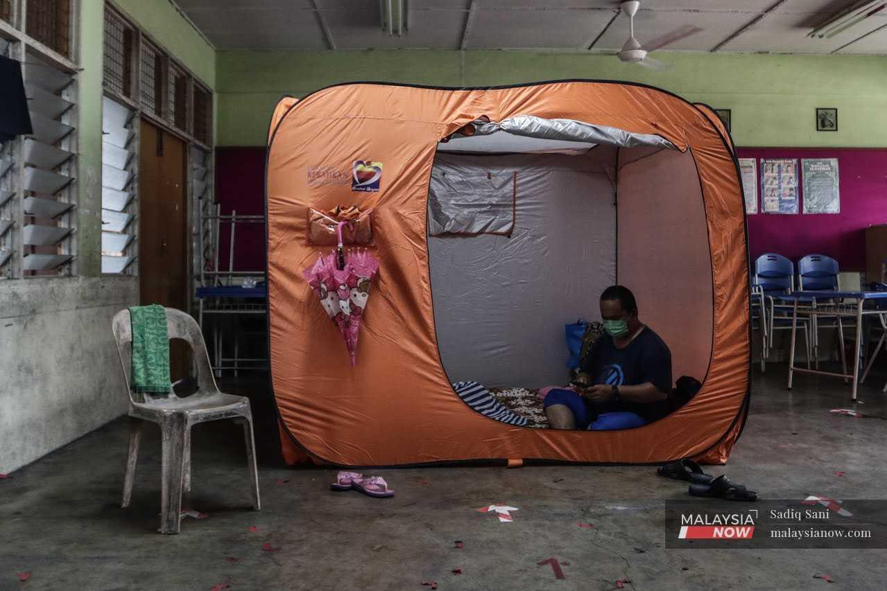 A man sits in a temporary shelter at a flood relief centre at a school in Klang, after the floods that swept through Klang, Kuala Langat and Sepang last year.