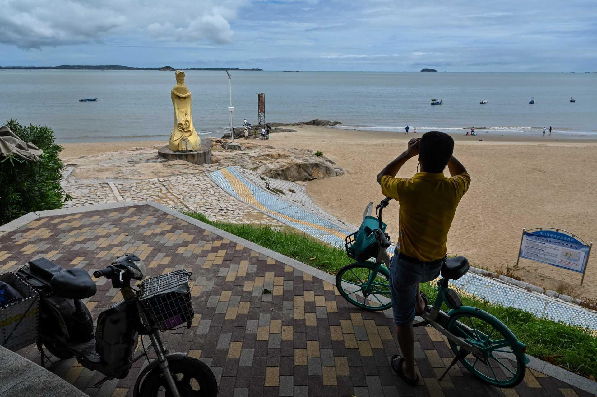 A man looks through a pair of binoculars in Xiamen, across Taiwan's Kinmen Islands on Aug 3. Photo: AFP 