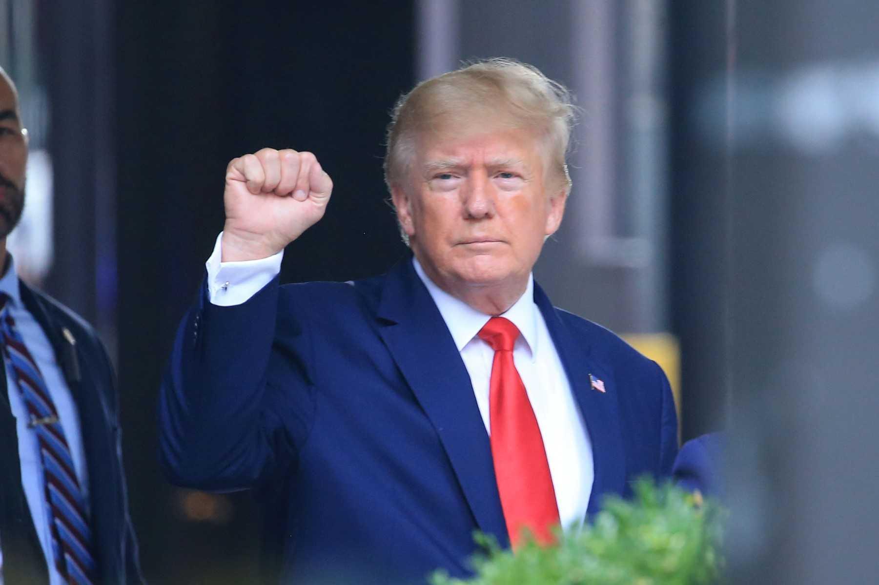 Former US president Donald Trump raises his fist while walking to a vehicle outside of Trump Tower in New York City on Aug 10. Photo: AFP