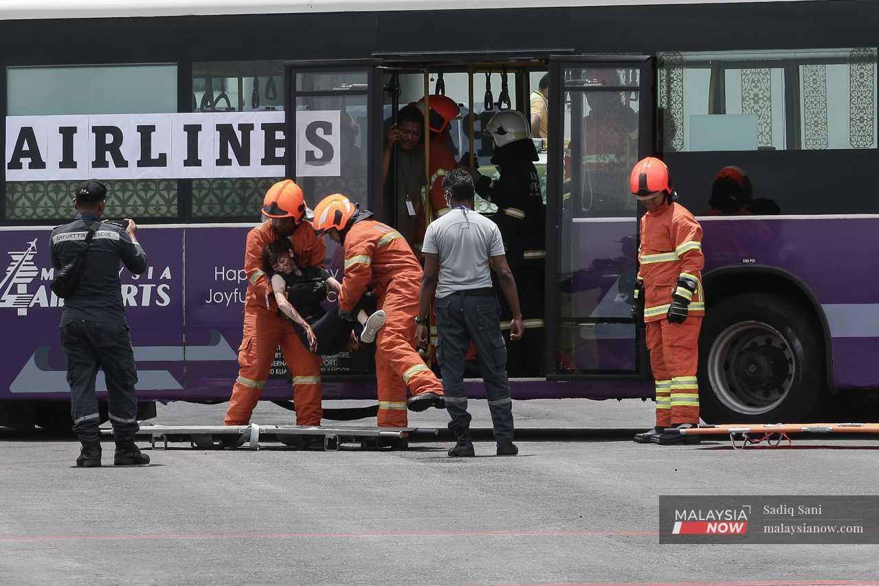 Anggota bomba dan penyelamat membawa seorang sukarelawan yang menjadi penumpang tercedera.