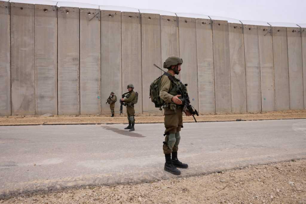 Israeli soldiers stand on guard by the fence along the border with the Gaza Strip near Moshav Netiv HaAsara in southern Israel on Dec 7, 2021. Photo: AFP