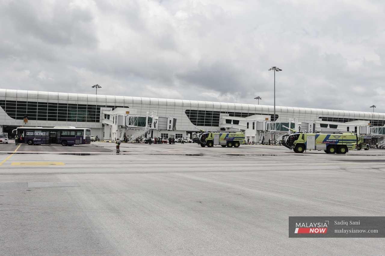 Airport Fire and Rescue Department trucks stand by at the scene of a fictitious plane crash at a yard in klia2, where this year's emergency drill exercise dubbed 'Perisai Panthera' was held. 