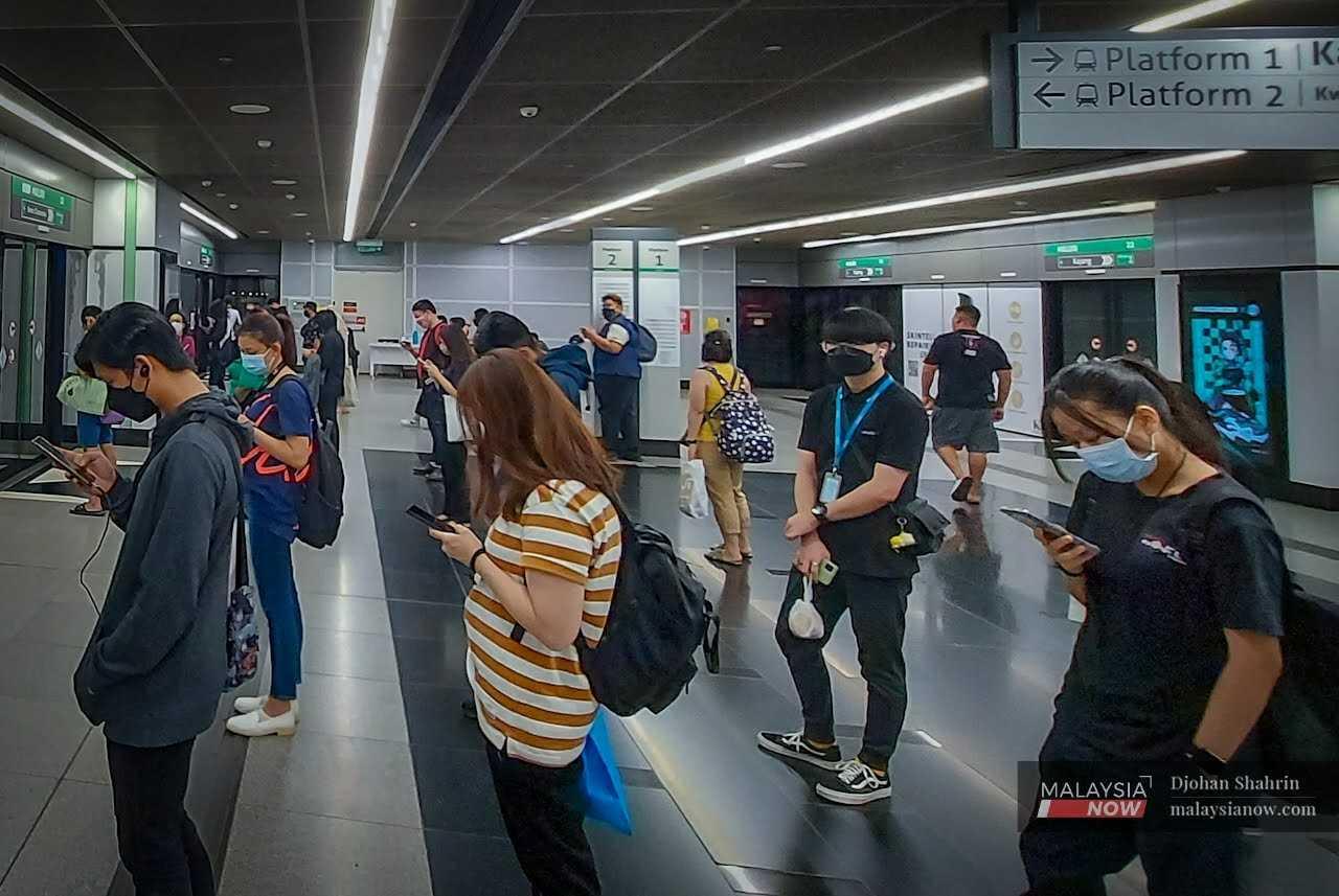 Commuters queue to enter a train at the Maluri MRT station in Cheras, Kuala Lumpur.
