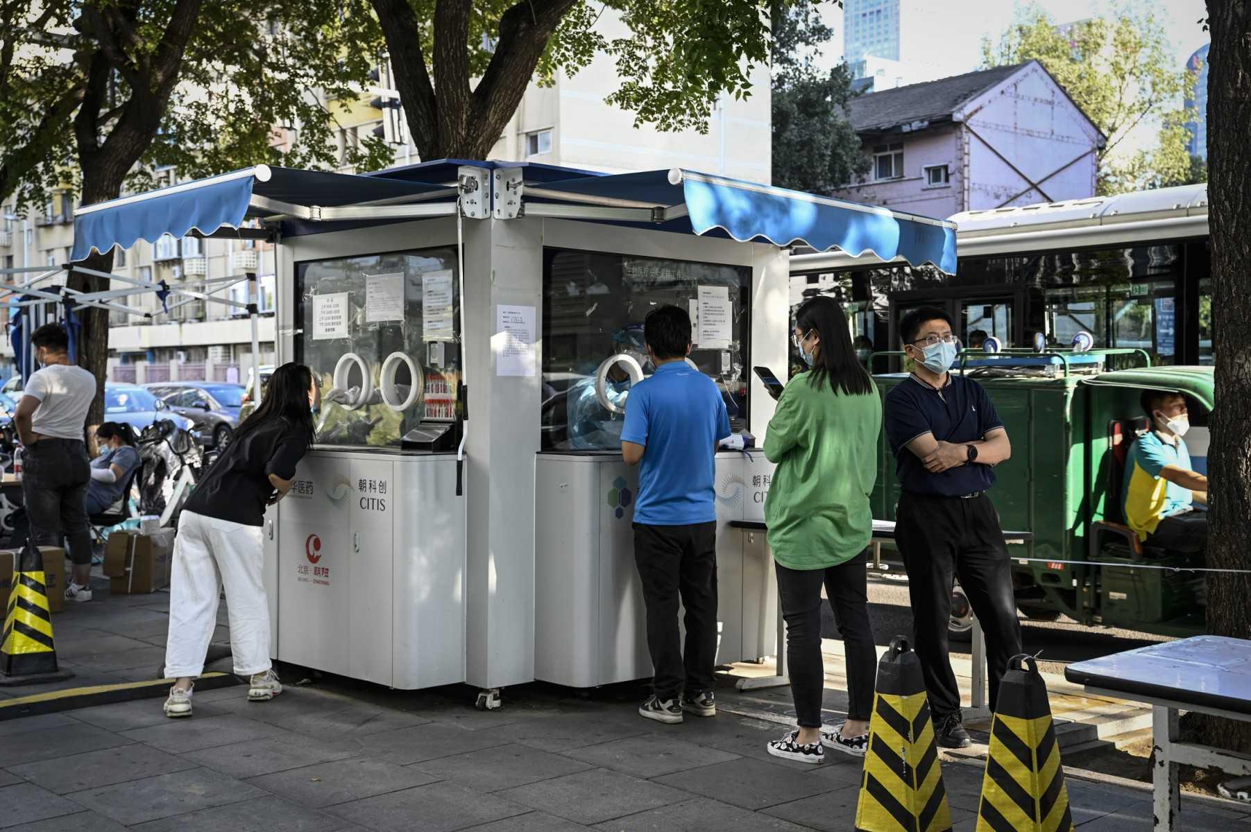 A health worker gets a swab sample from a woman to be tested for Covid-19 at a nucleic acid testing station along a street in Beijing on Sept 15. Photo: AFP