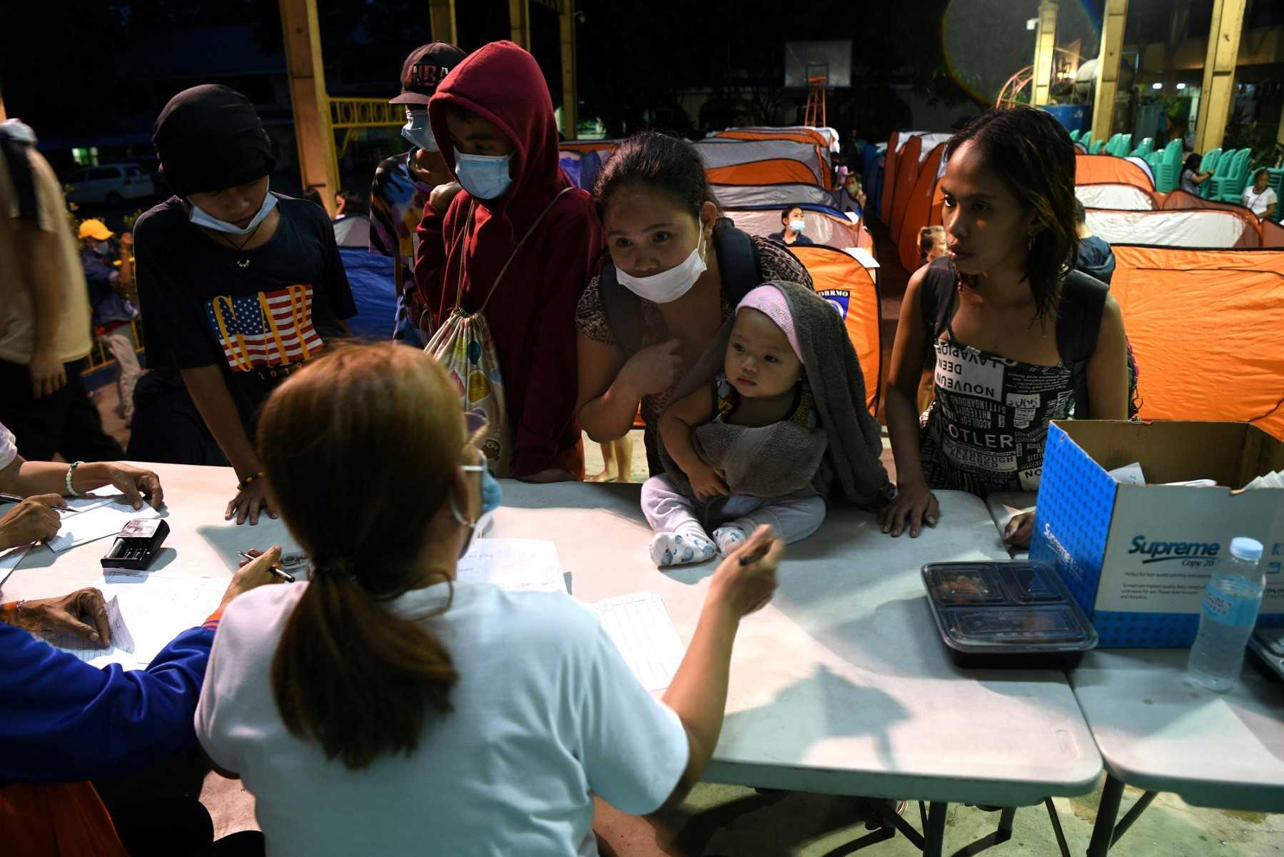 A family with their belongings arrive at an evacuation centre in Quezon city suburban Manila on Sept 25, as Super Typhoon Noru slammed into the Philippines. Photo: AFP