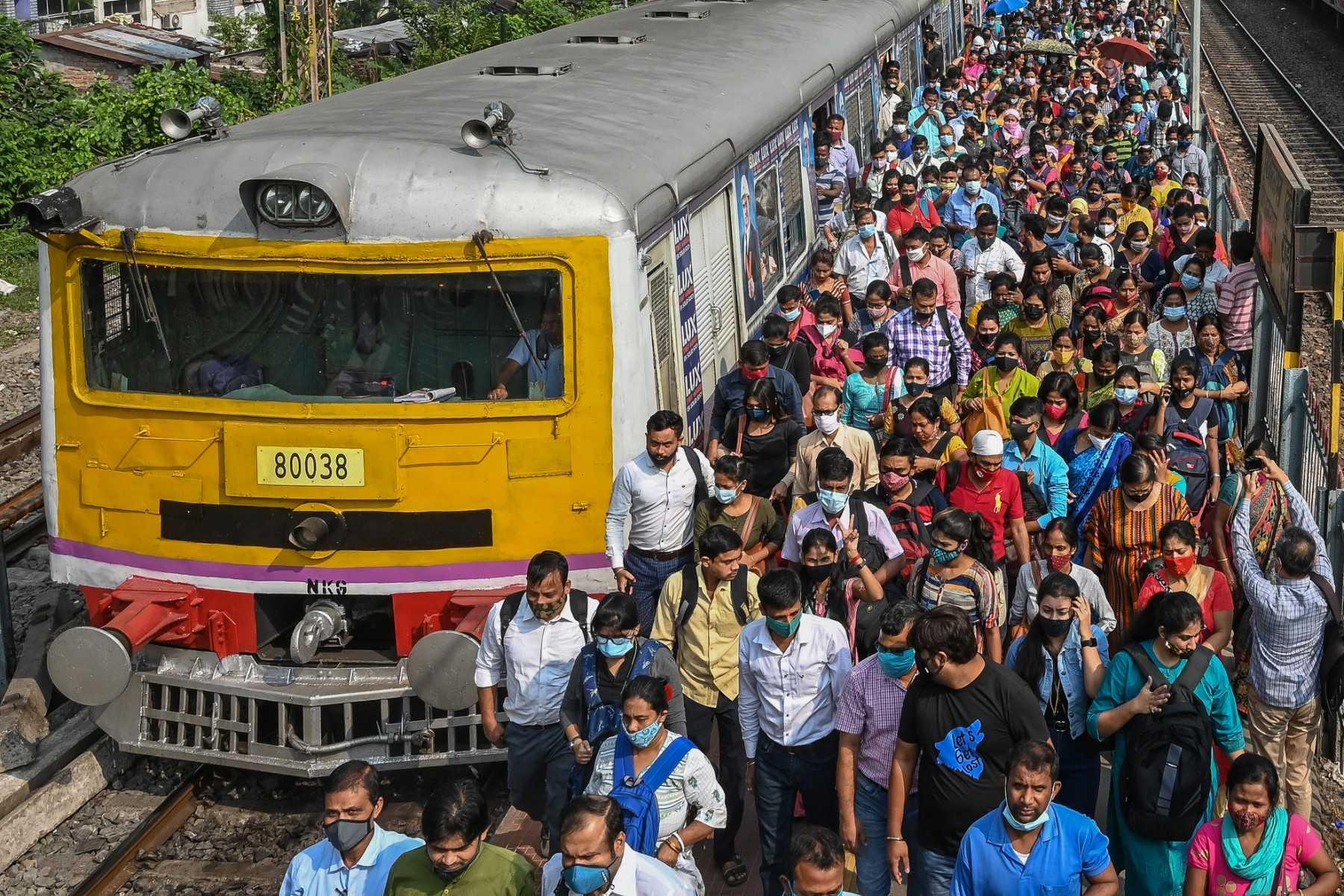 Commuters walk along a railway platform after stepping out from a suburban local train in Kolkata on Nov 1, 2021. Photo: AFP