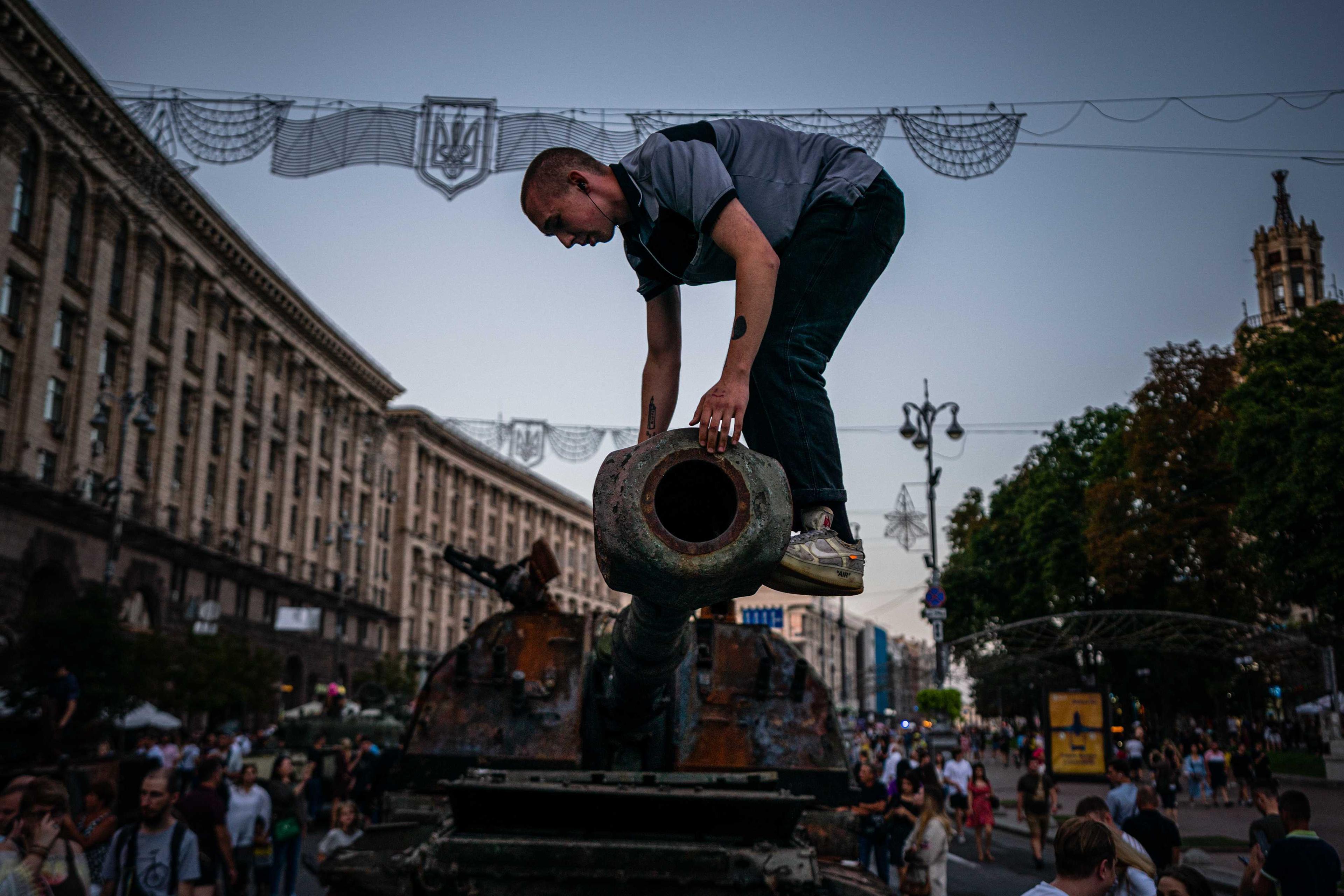 In this photograph taken on Aug 21, a man climbs on a destroyed Russian tank at Khreshchatyk street in Kyiv, that has been turned into an open-air military museum ahead of Ukraine's Independence Day on Aug 24, amid Russia's invasion of Ukraine. Photo: AFP 