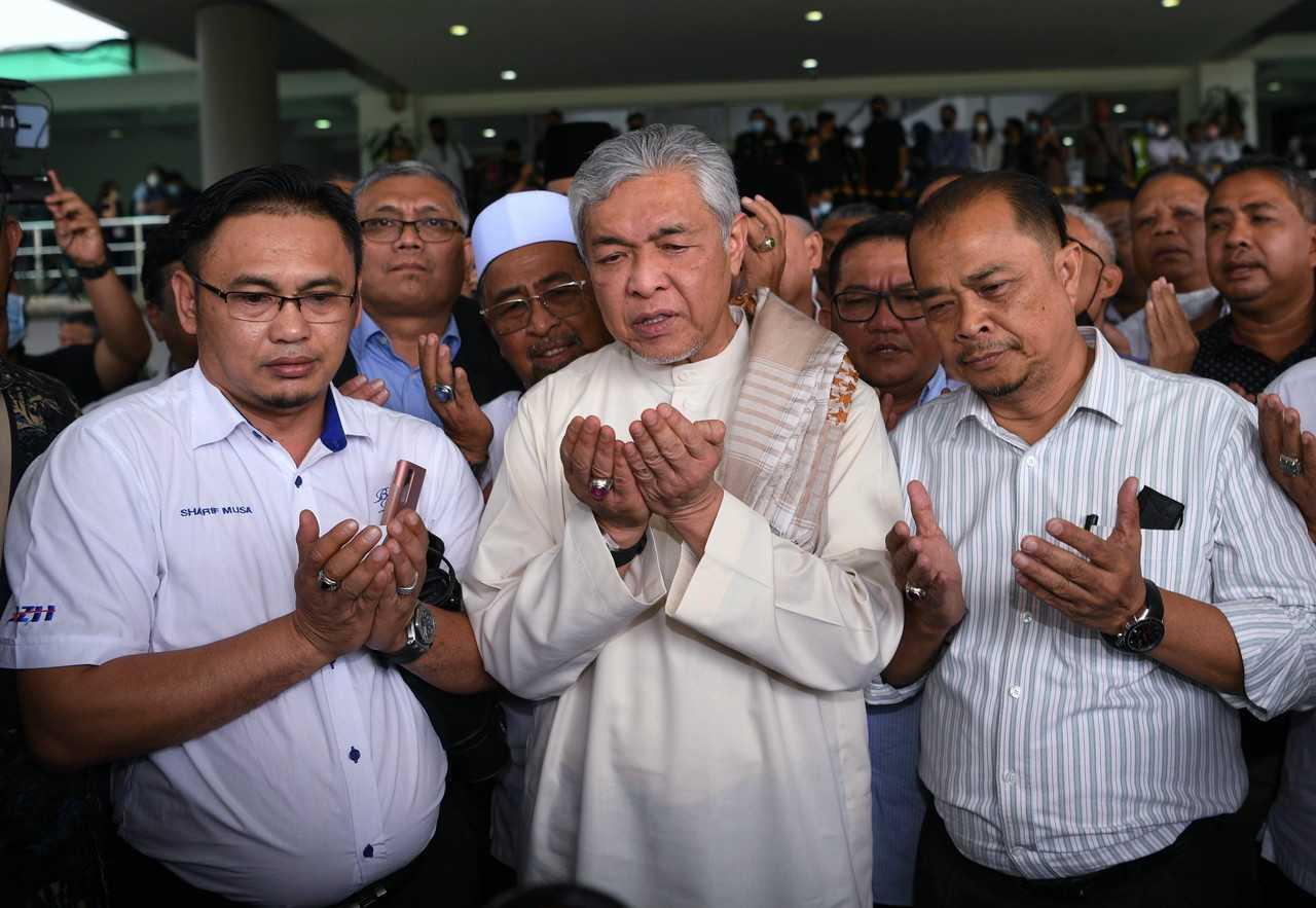 Umno president Ahmad Zahid Hamidi (centre) says a prayer of thanksgiving after being acquitted of 40 charges of corruption by the Shah Alam High Court on Sept 23. Photo: Bernama